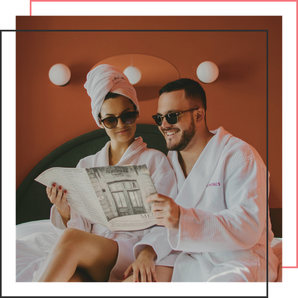 couple wearing robes and sunglasses smiling