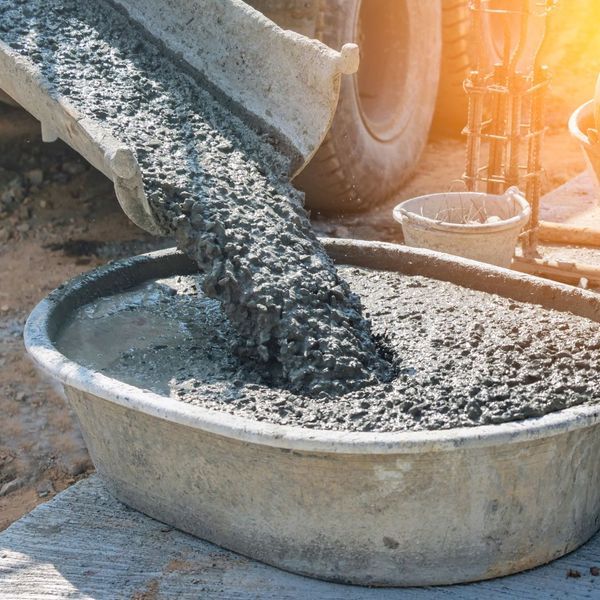 wet concrete pouring out of a mixing truck