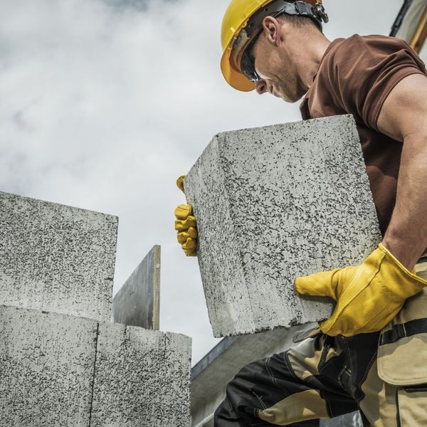 Construction working holding concrete block