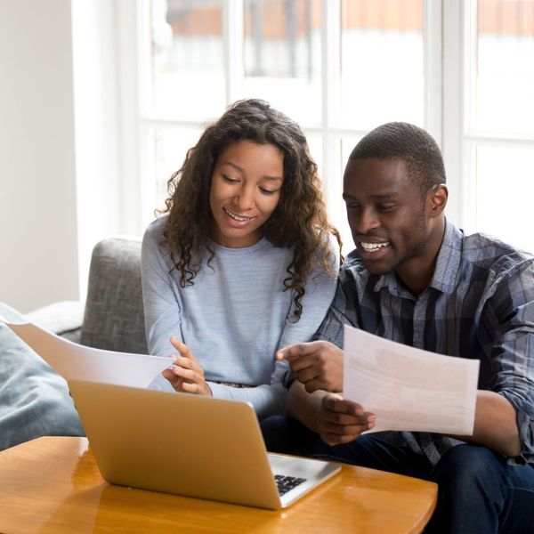 smiling couple looking at reduced bills