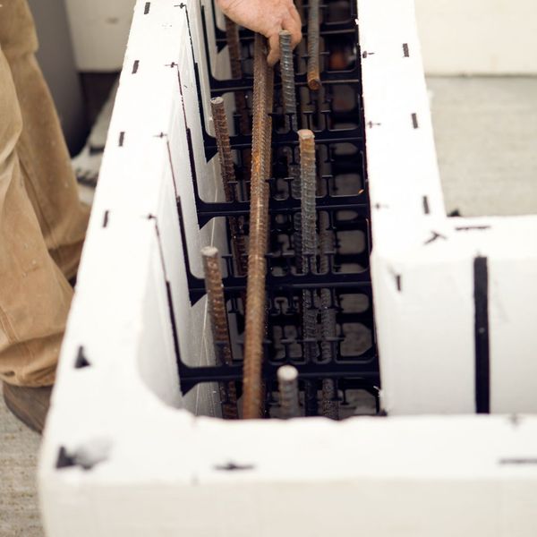 Construction Worker Installing Reinforcement Bar in an Insulated Concrete Form