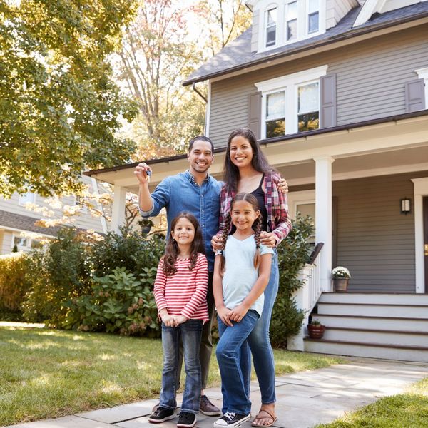 family in front of their new house holding their keys