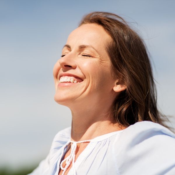 Woman closing eyes and smiling outside