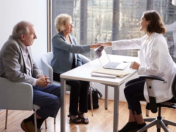 Doctor meeting an older couple in her office.