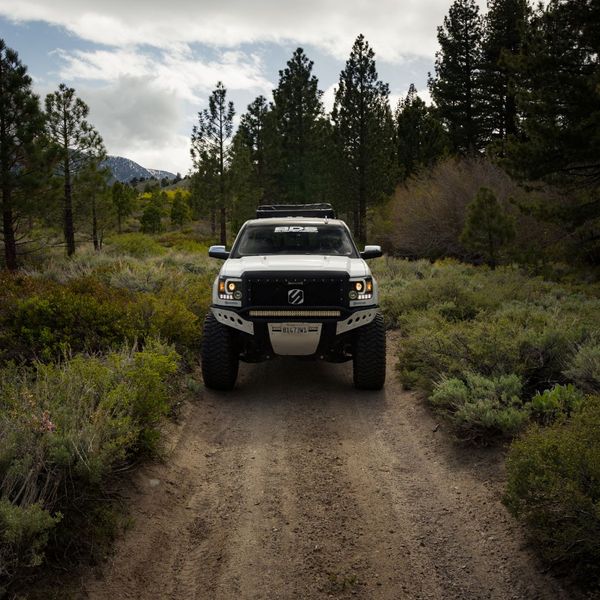 front of a lifted truck on a dirt trail