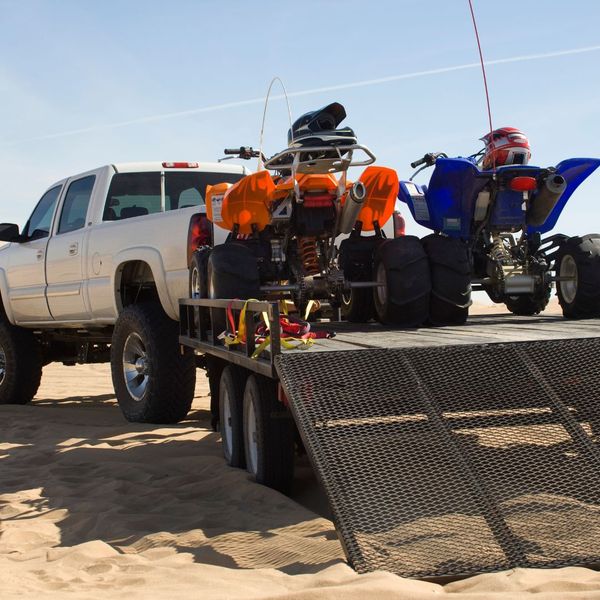 lifted truck pulling a trailer with ATVs