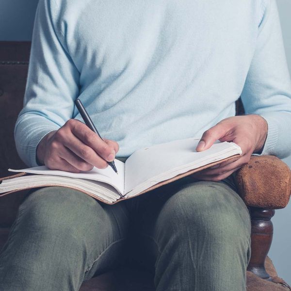 Man writing something in a journal. 
