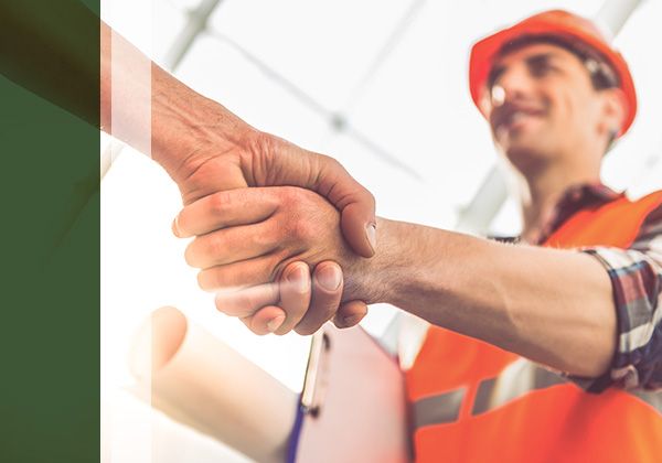 handshake with roofer holding plans