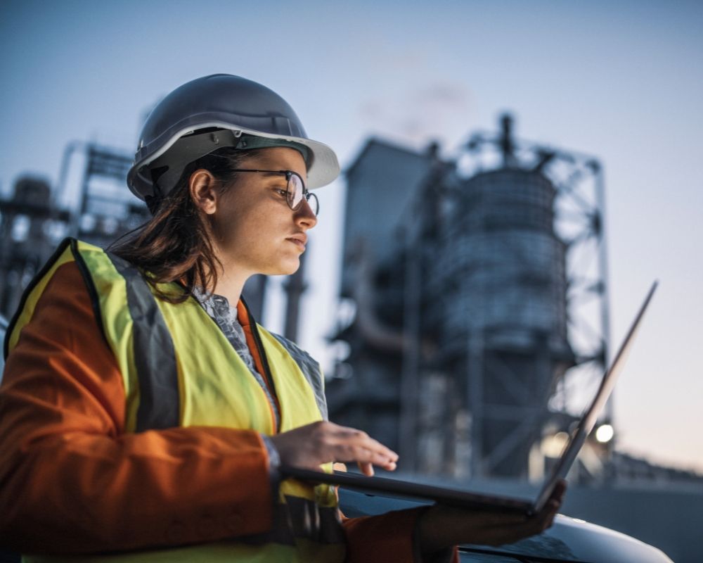 Female engineer at power plant with laptop