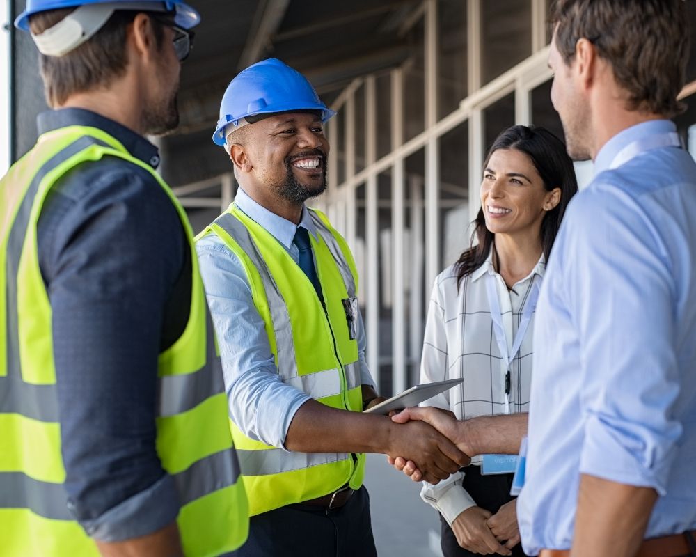 A safety expert shaking hands with clients outside an office