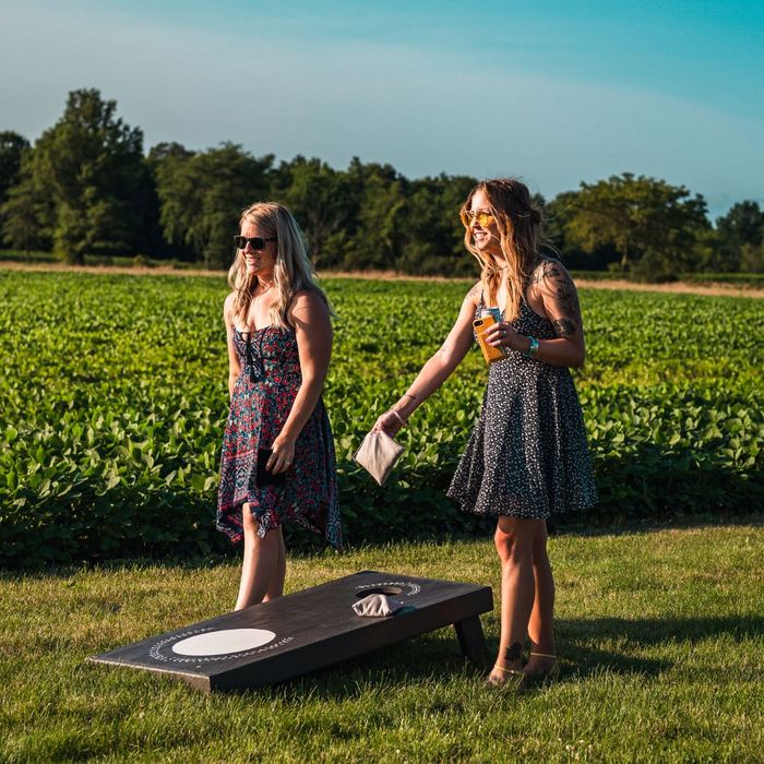 two women playing cornhole at winery two women playing cornhole at winery