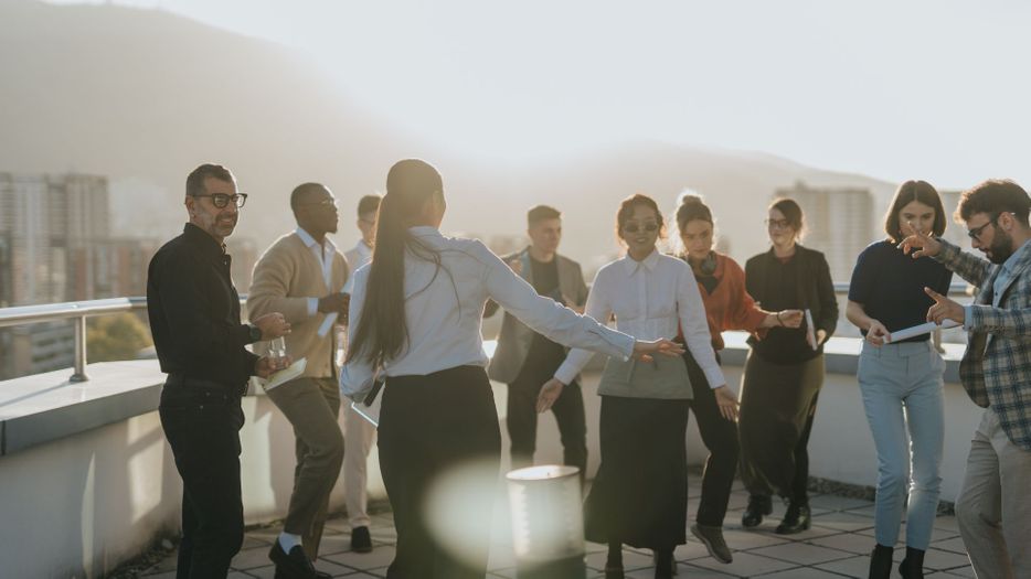 group of people celebrating on rooftop at sunset