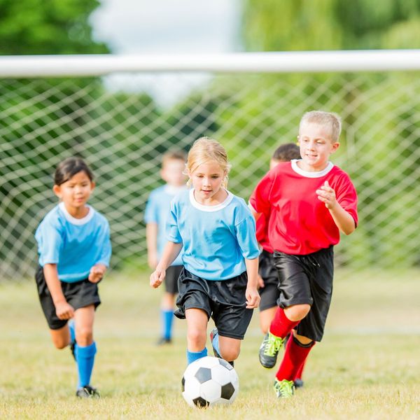 young children playing soccer