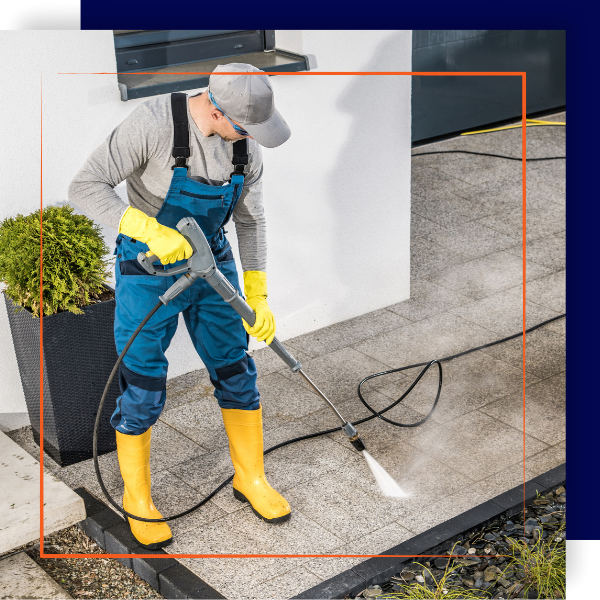 Contractor pressure washing concrete residential patio.