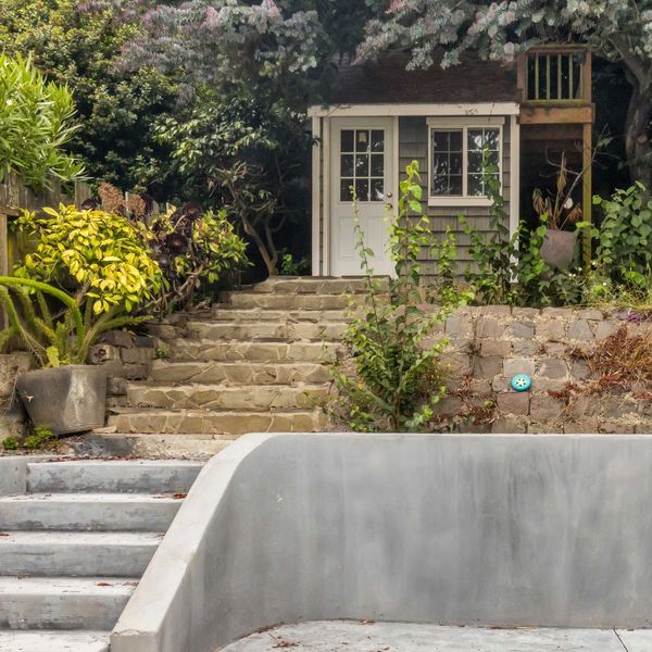 small guest house or standalone room up stone stairs in backyard