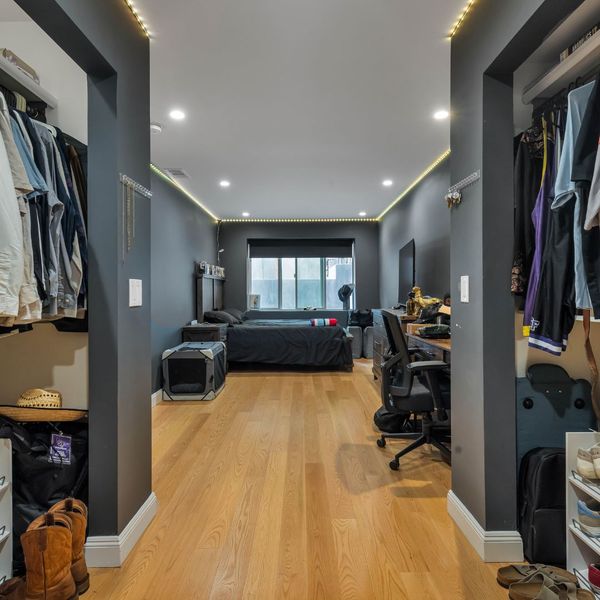 long bedroom with closets and office desk