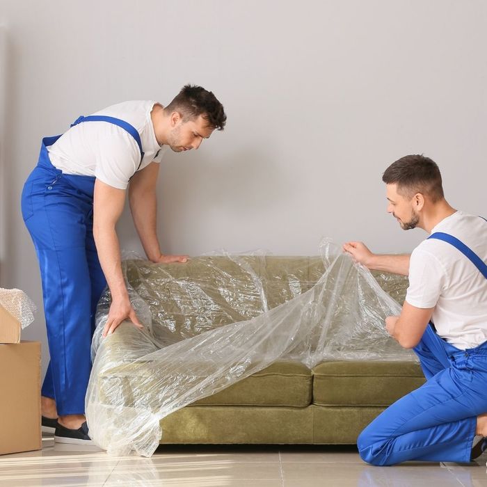men wrapping couch