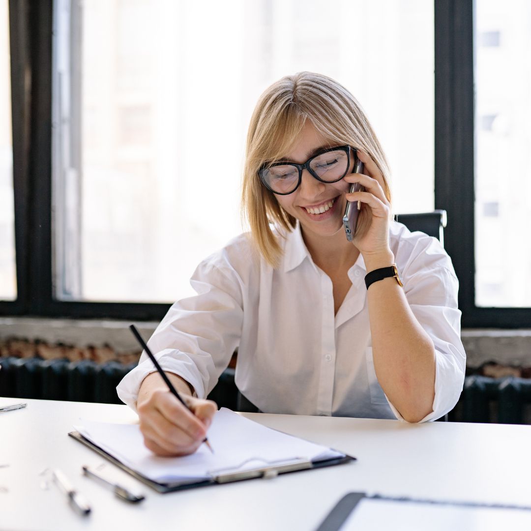 Woman on phone call with pen and paper