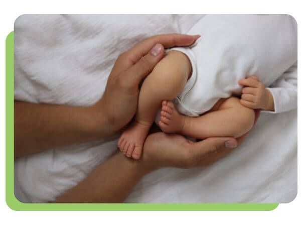 gentle hands holding infant legs