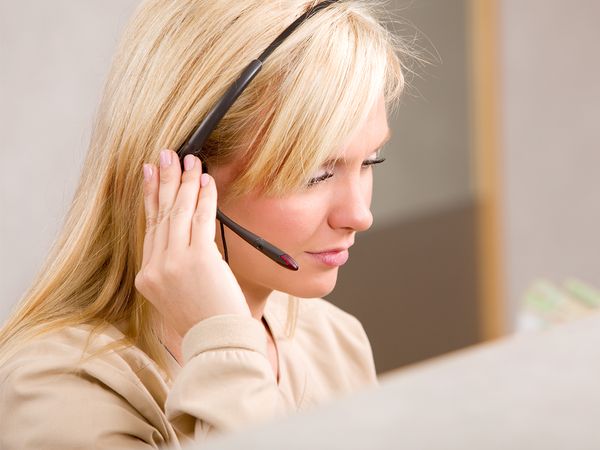 A receptionist talking on the phone with a headset 