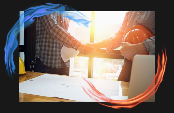 A contractor and a business owner holding hard hats and shaking hands