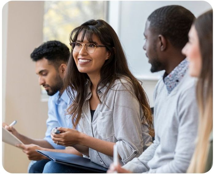 Group of people sitting in a row and taking notes