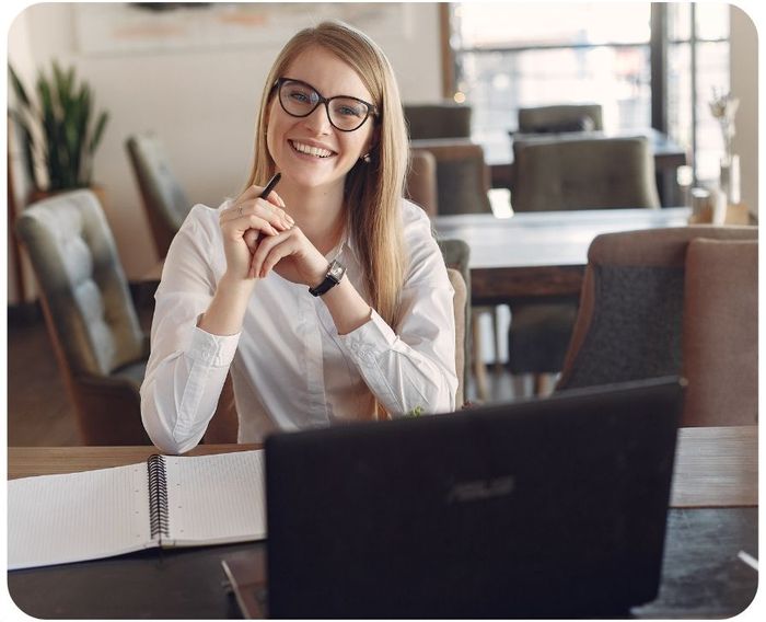 Professional person smiling while sitting at a laptop