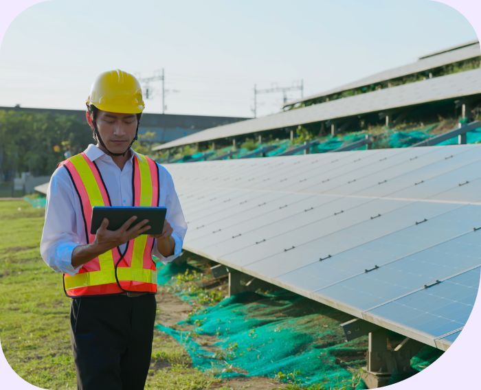 a man in safety gear on a tablet in front of a solar field a man in safety gear on a tablet in front of a solar field