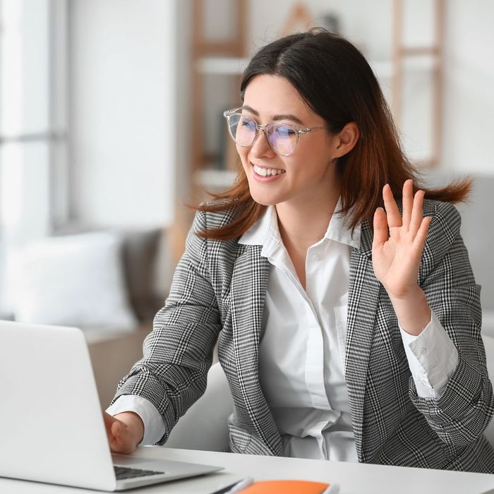 smiling and waving at the computer