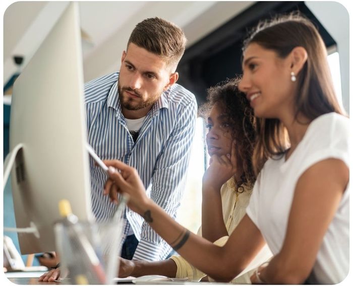 Three people working at a computer