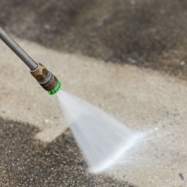 close up of power washing concrete