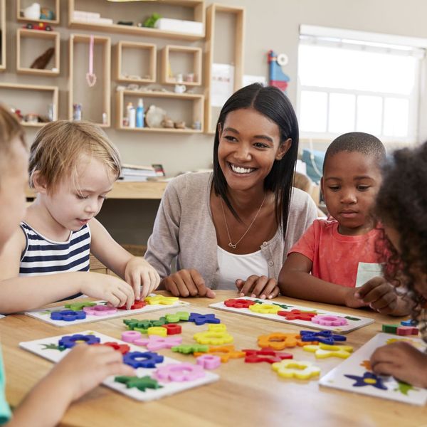 a teacher helping kids with shapes Our Unique Educational Philosophy (3).jpg