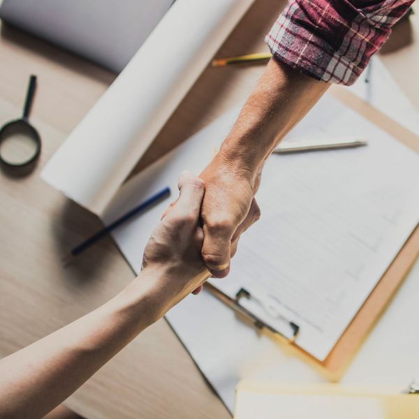 a homeowner and a roofing contractor shaking hands