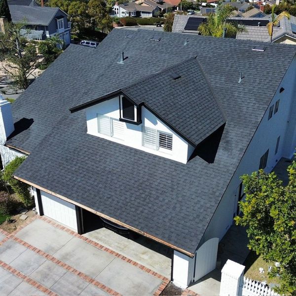 The exterior of a charming suburban home showcases the rich texture of its traditional shingle roof.