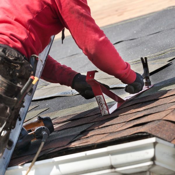 roofer hammering in shingles