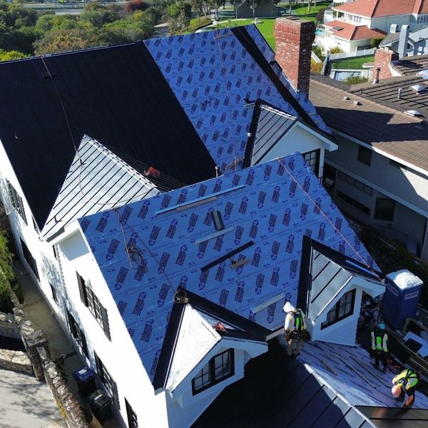 construction workers working on a standing Seam Metal roof