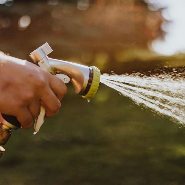 person spraying garden hose