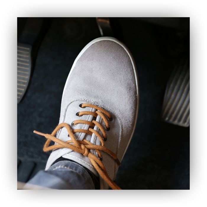 Foot above a brake pedal