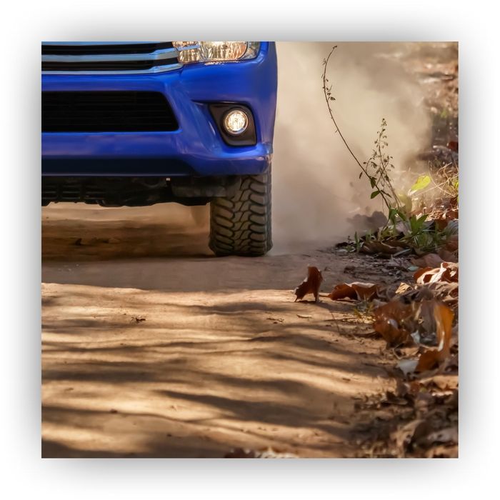 Blue car driving on a dirt road