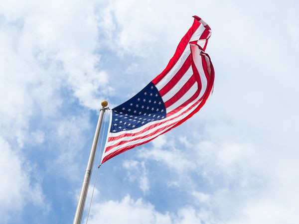 An American flag waving in the wind on a bright cloudy day