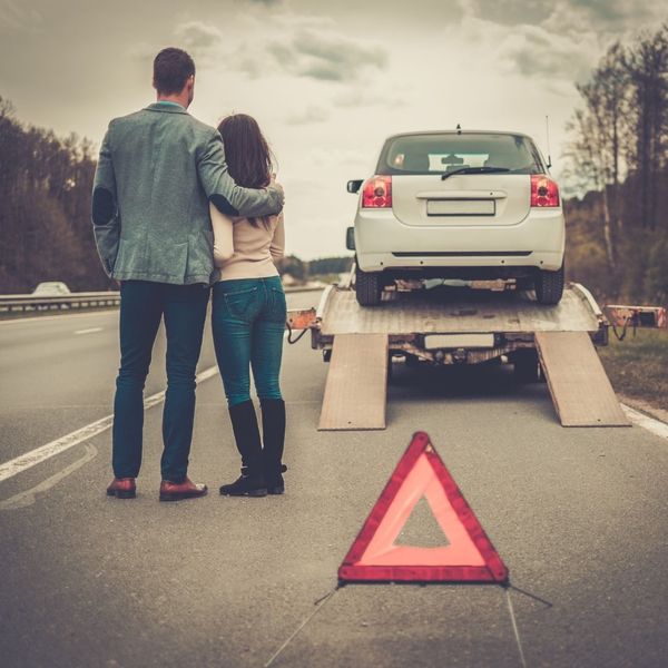 a couple watching their vehicle be towed 4 Signs You Need Professional Towing (2).jpg