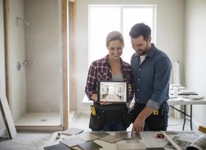 Couple planning home renovation with tablet and tile samples