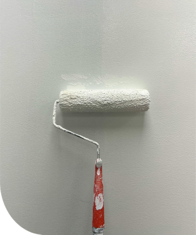 a roller brush painting a wall