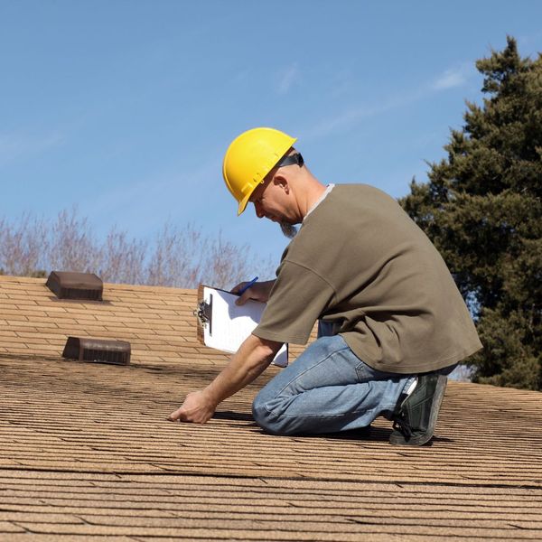 checking roof with clipboard 