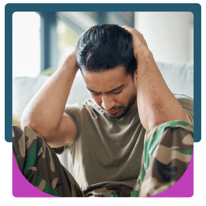 Man in camo holding his head