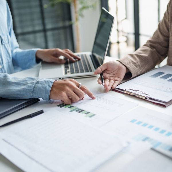 A tax professional working with a business owner, looking over tax documents.