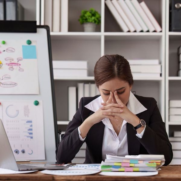 stressed out business owner surrounded by paperwork