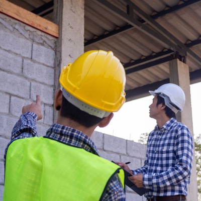 contractors wearing hard hats inspecting building