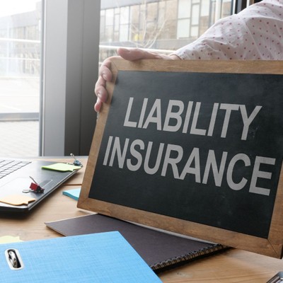 Person holding a sign that says Liability Insurance