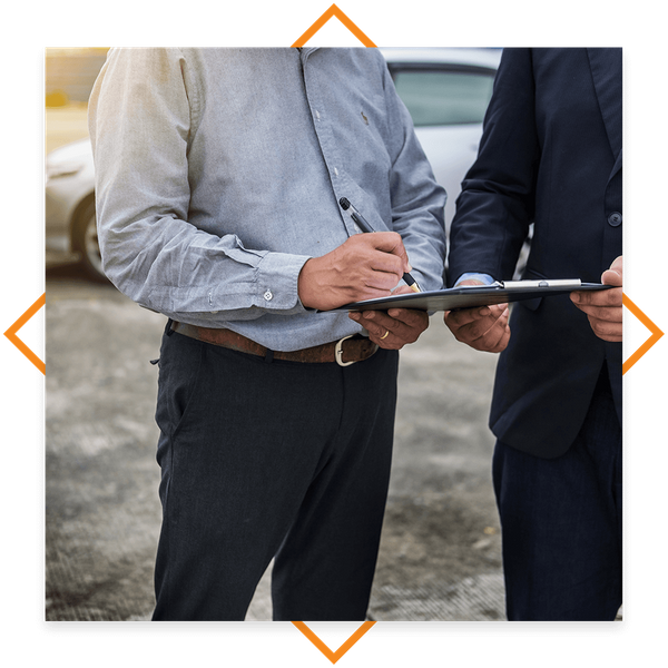 Business owner signing paperwork to insure their vehicles